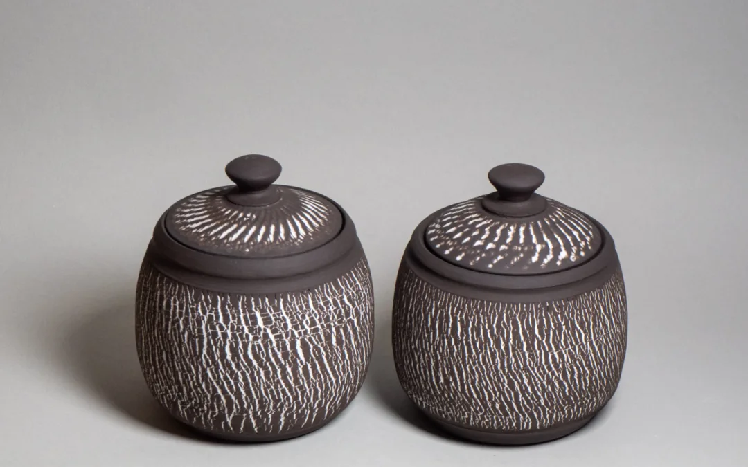 Storage jars from black stoneware and white chattered and treatrunk texture