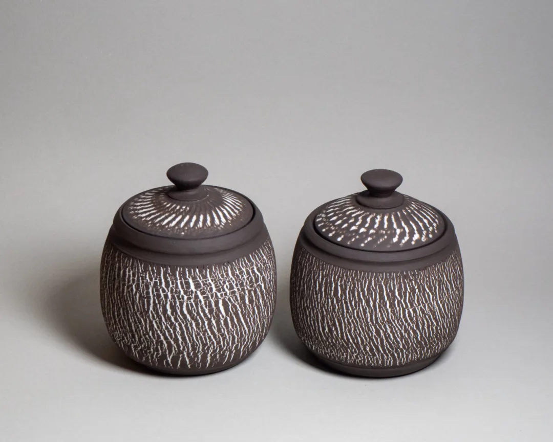 Storage jars from black stoneware and white chattered and tree trunk texture