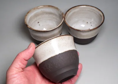 Tea bowls from black stoneware with white glossy glaze