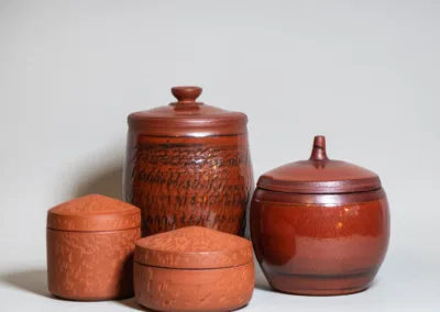 Lidded jars from red clay. Unglazed and with rusty red glaze