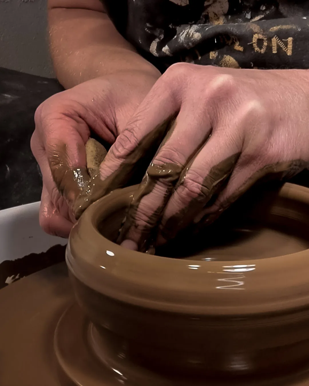 Potters hands throwing a pot Potters hands throwing a pot on potter's wheel