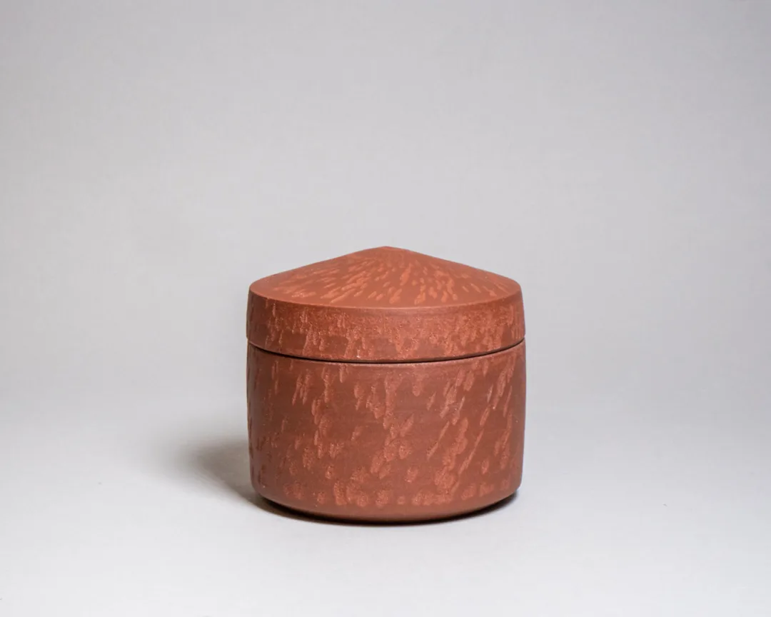 Lidded jar from red stoneware and chattered texture