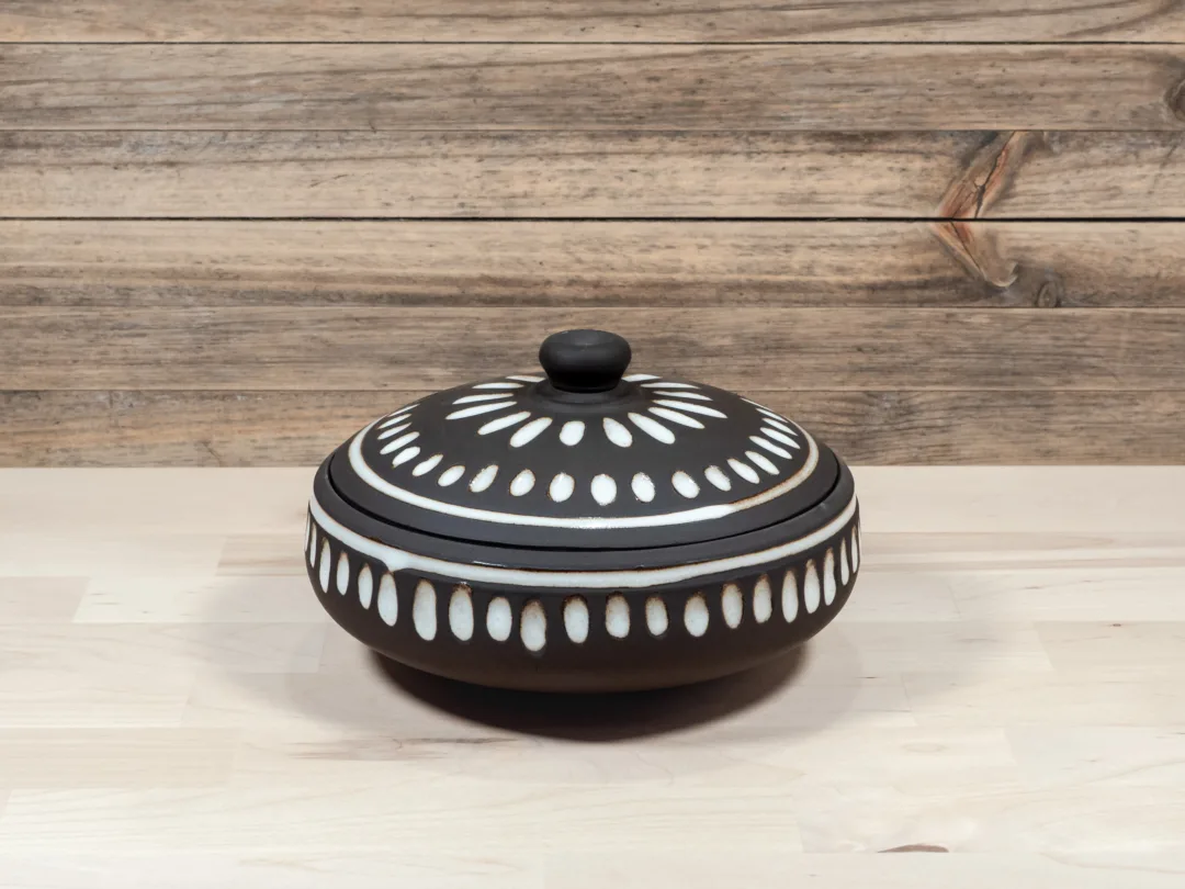 Wide and shallow lidded jar from black stoneware and white fluted texture